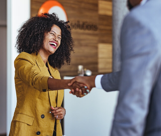 Mulher sorrindo comprimentando um homem